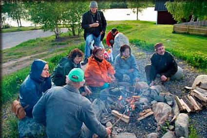 たき火を囲んでソーセージを焼く
